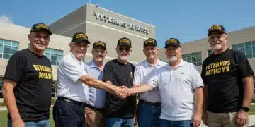 Veterans smiling in front of a VA building, symbolizing updated benefits and support.