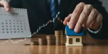 Hand placing coins on house, symbolizing Fed rate hike impact on personal finances in January 2026