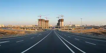 Modern highway interchange with construction cranes symbolizing infrastructure progress.